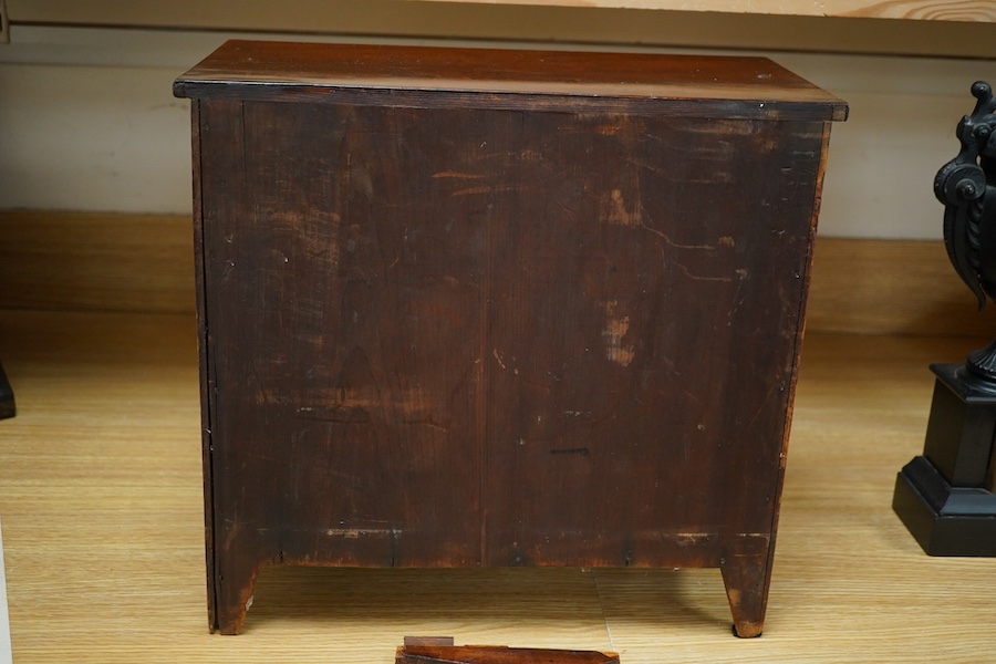 An early 20th century mahogany miniature chest of drawers, 39cm tall. Condition - one piece detached